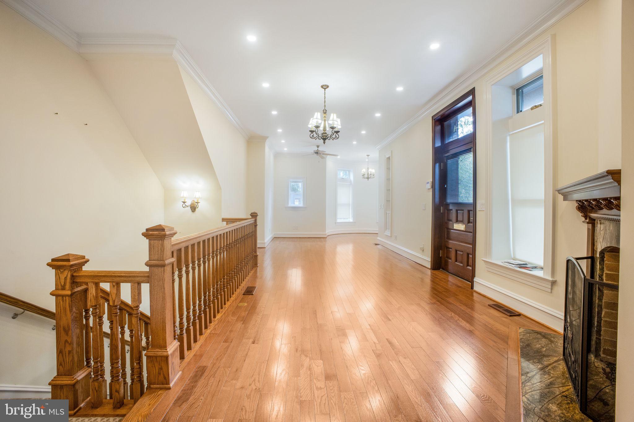 a view of a hallway with wooden floor and staircase