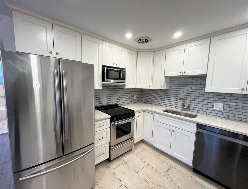 a kitchen with stainless steel appliances granite countertop a refrigerator sink and cabinets