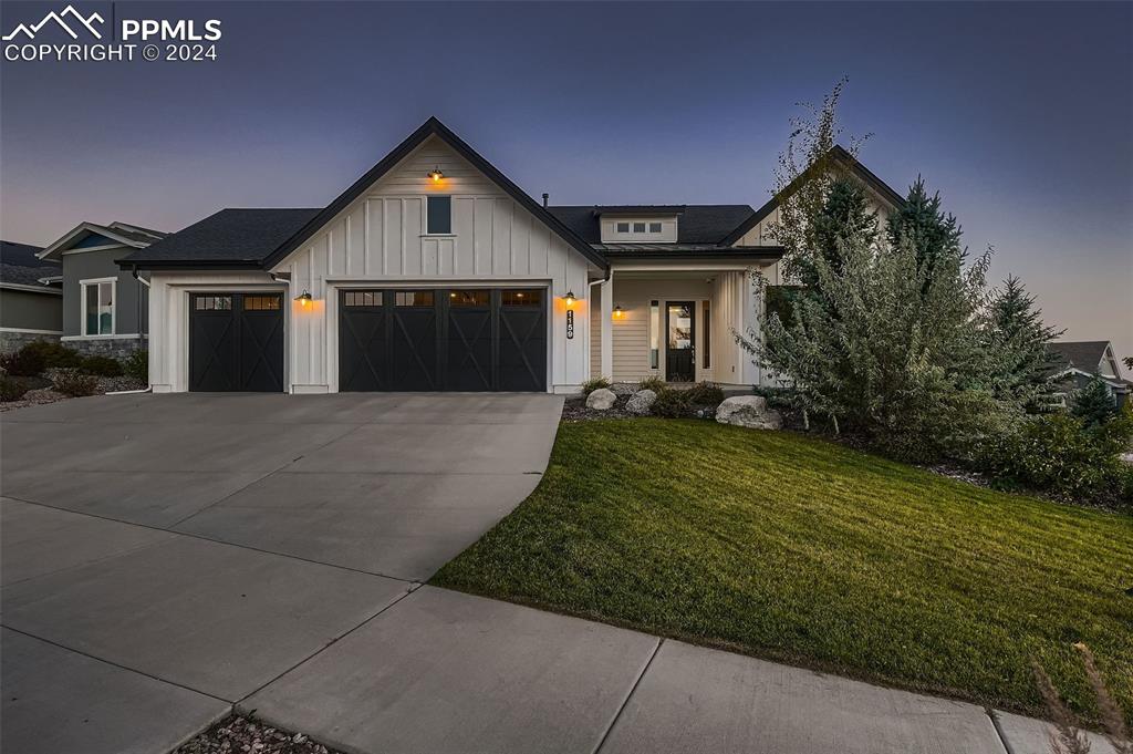 Modern farmhouse style home featuring a lawn and a garage