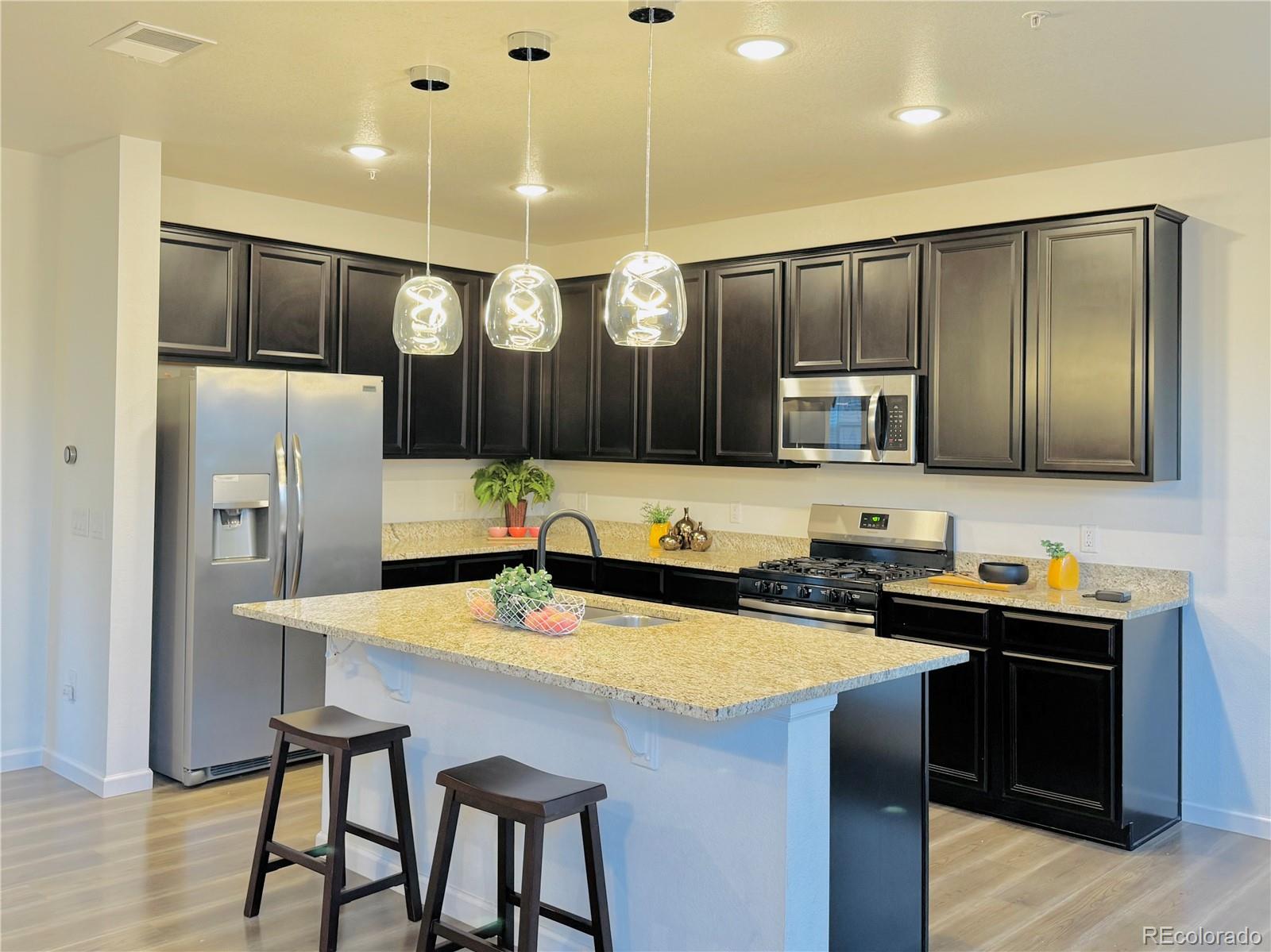 a kitchen with stainless steel appliances a sink stove and refrigerator