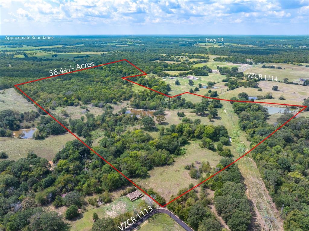 an aerial view of residential houses with outdoor space and trees