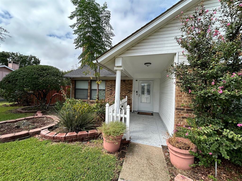 a front view of a house with a yard and potted plants