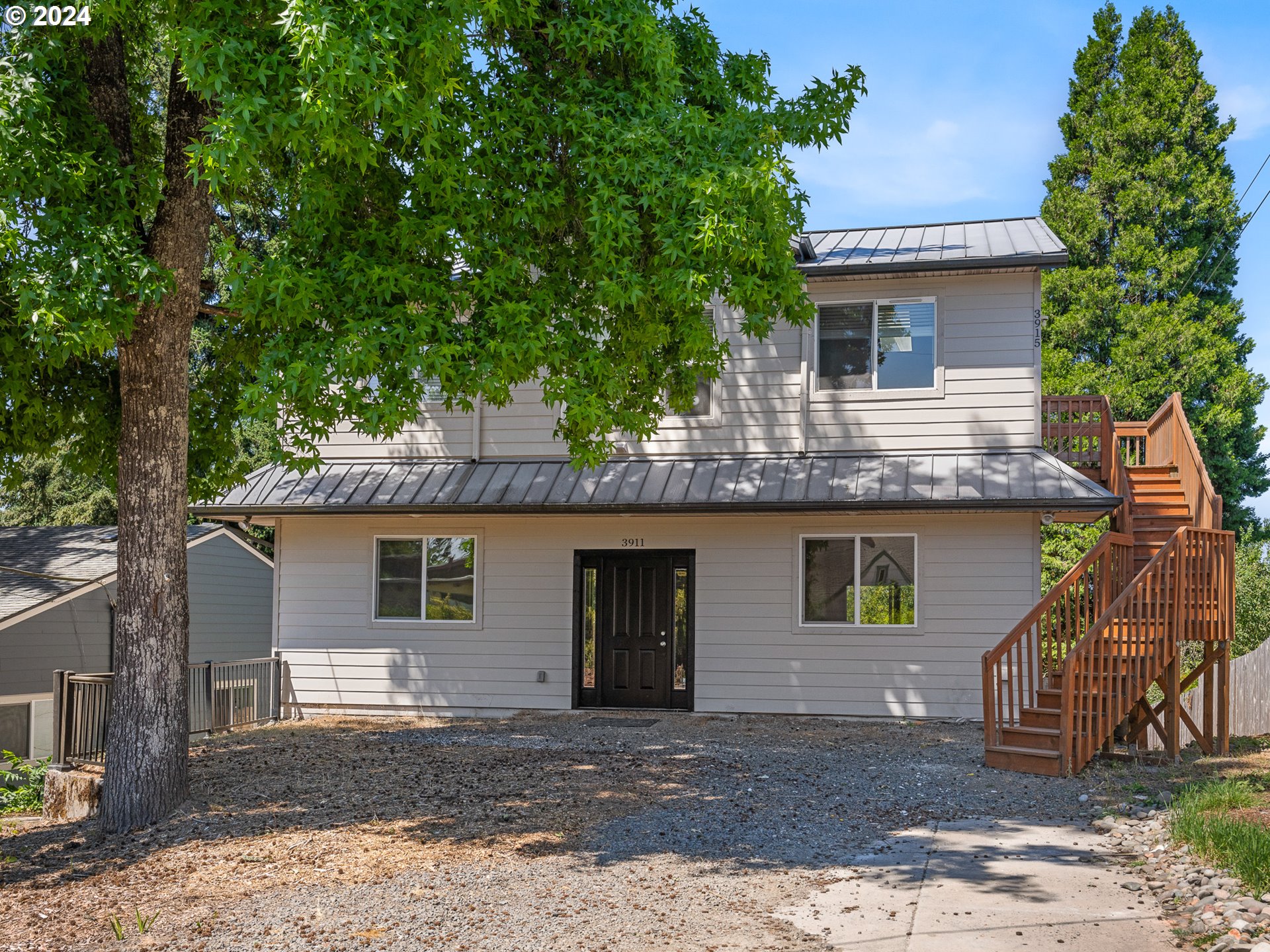 a front view of a house with a tree