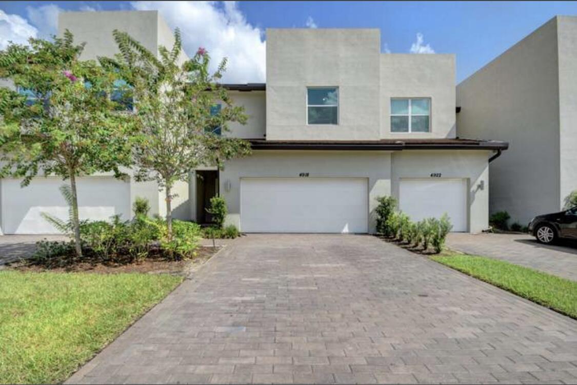 a front view of a house with a yard and a garage