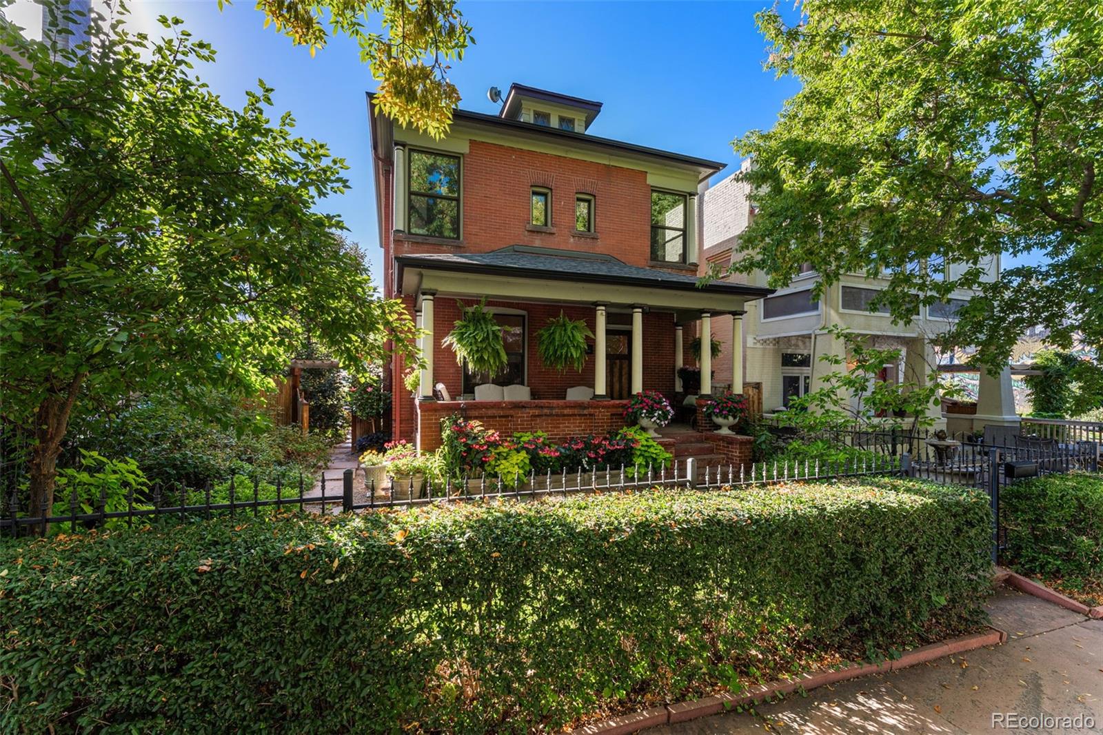 a view of house with a big yard and large trees