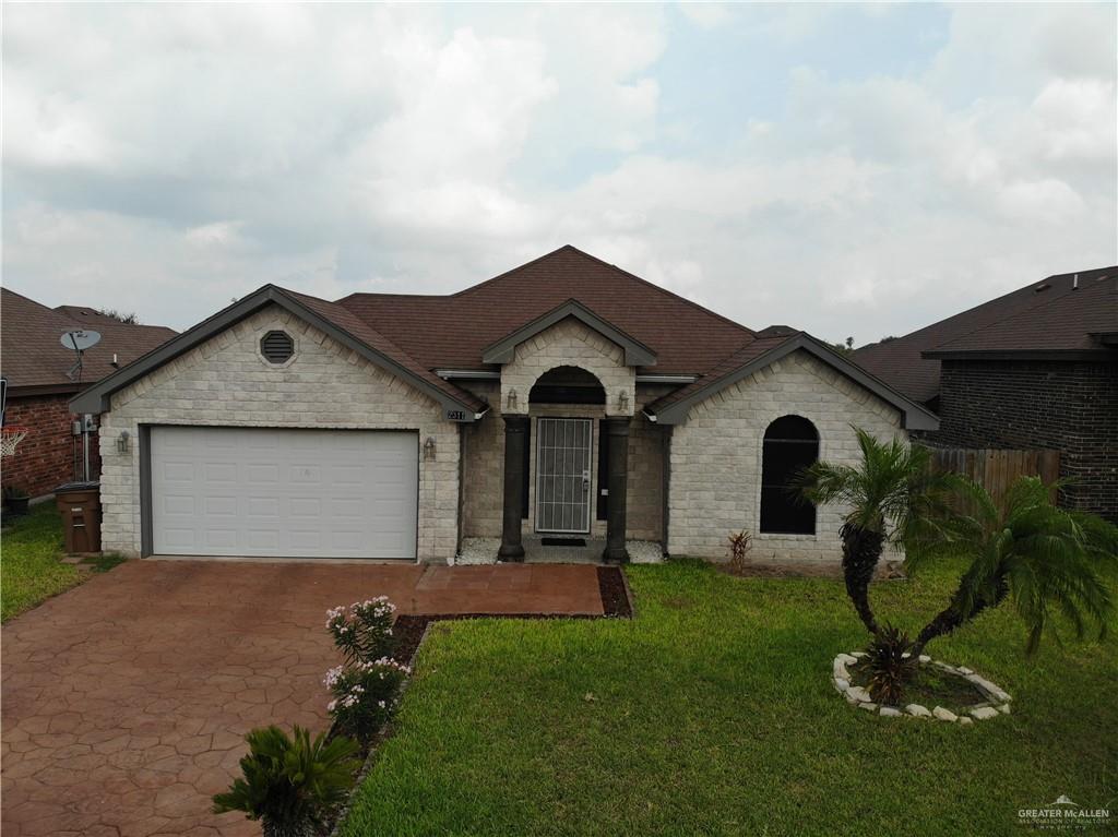 Ranch-style house with a front yard and a garage