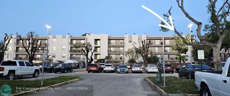 a view of a building with cars parked