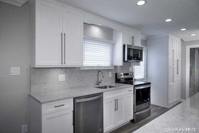 a kitchen with granite countertop white cabinets sink and stainless steel appliances