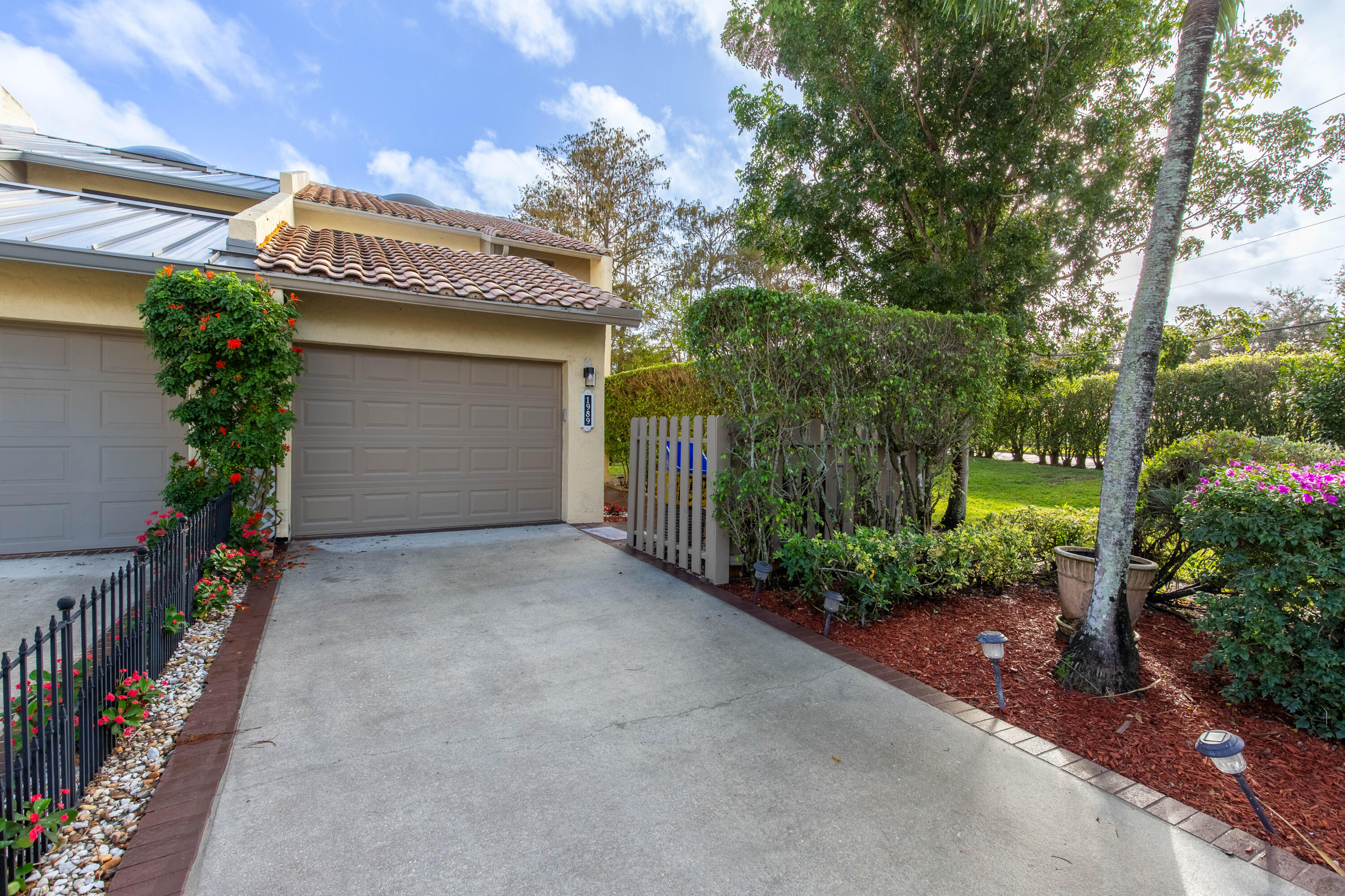 a view of a house with garage and plants