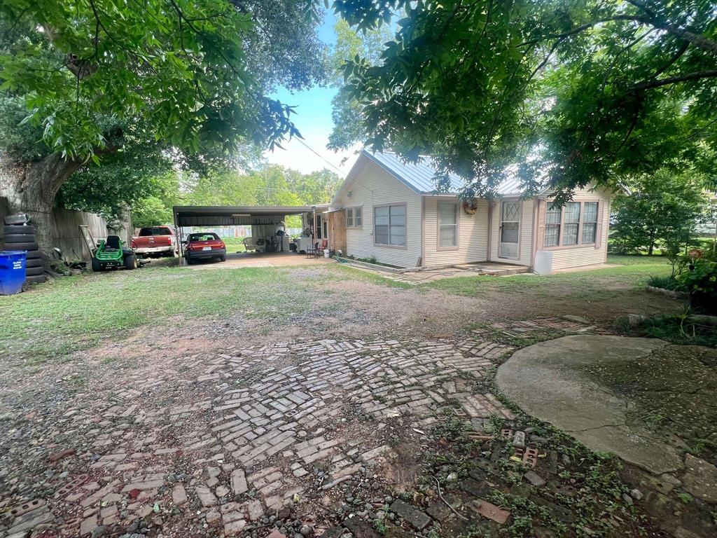 a front view of a house with a yard and trees