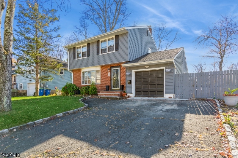 a front view of a house with garden and parking