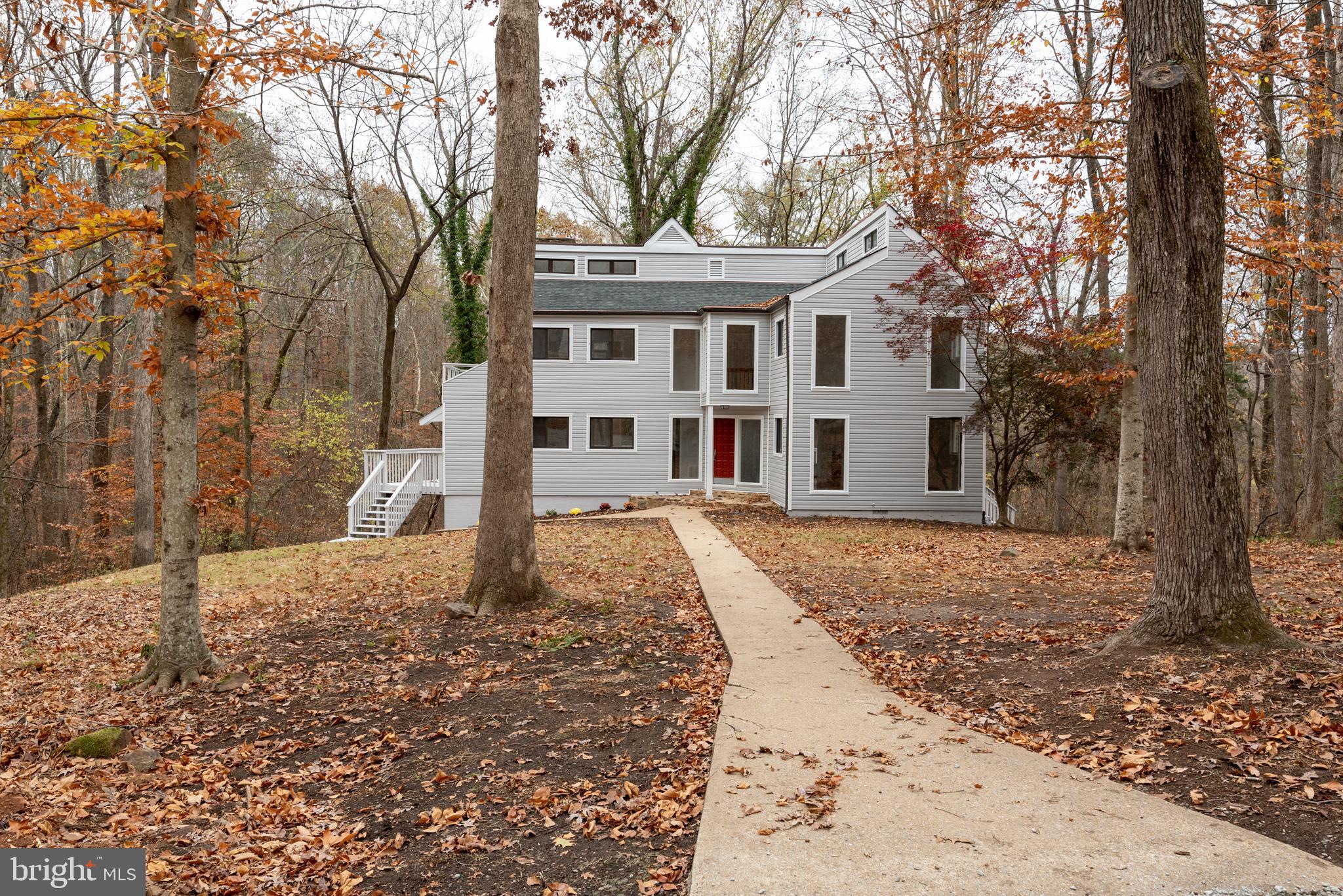 a front view of a house with a yard and large trees