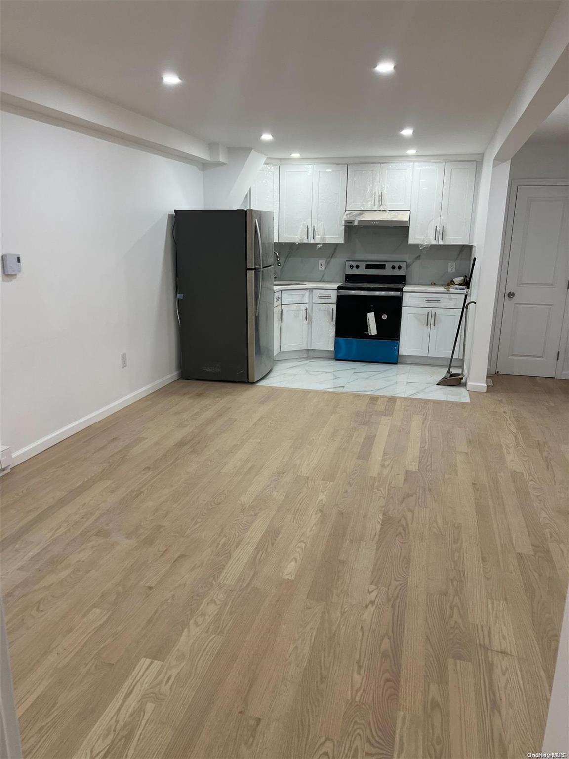 a view of kitchen with kitchen island microwave and refrigerator