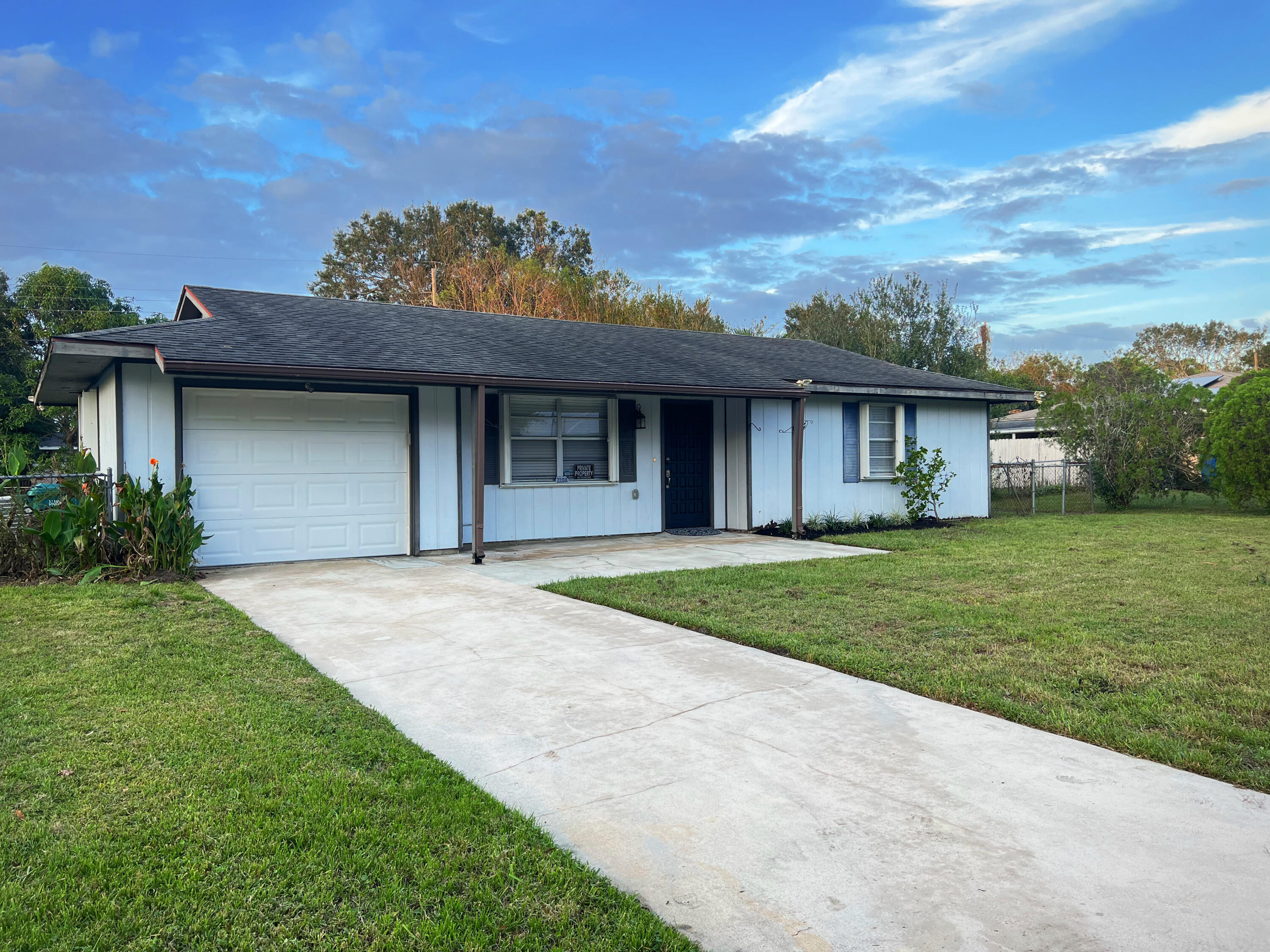 a front view of a house with a garden and yard