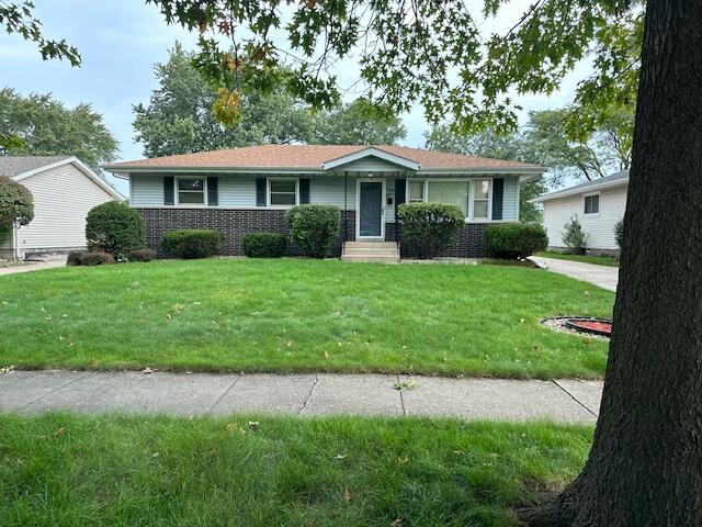 a front view of a house with a yard and trees