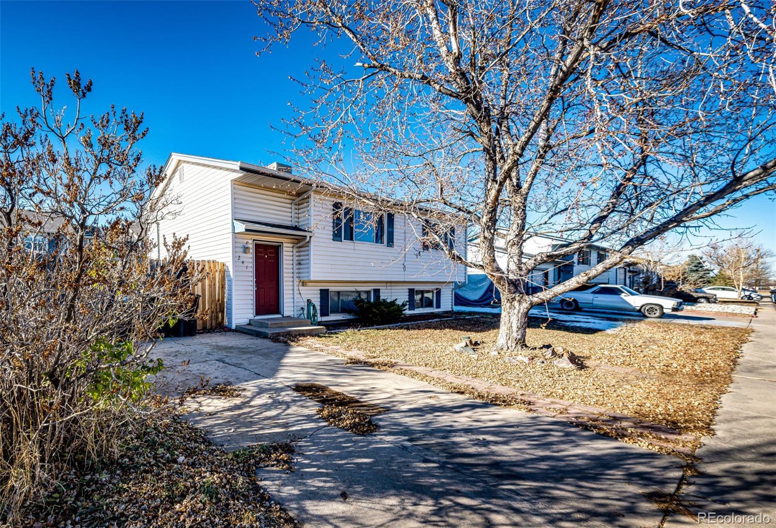 a front view of a house with a yard covered with snow