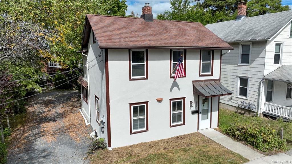 a brick house with large windows and a yard