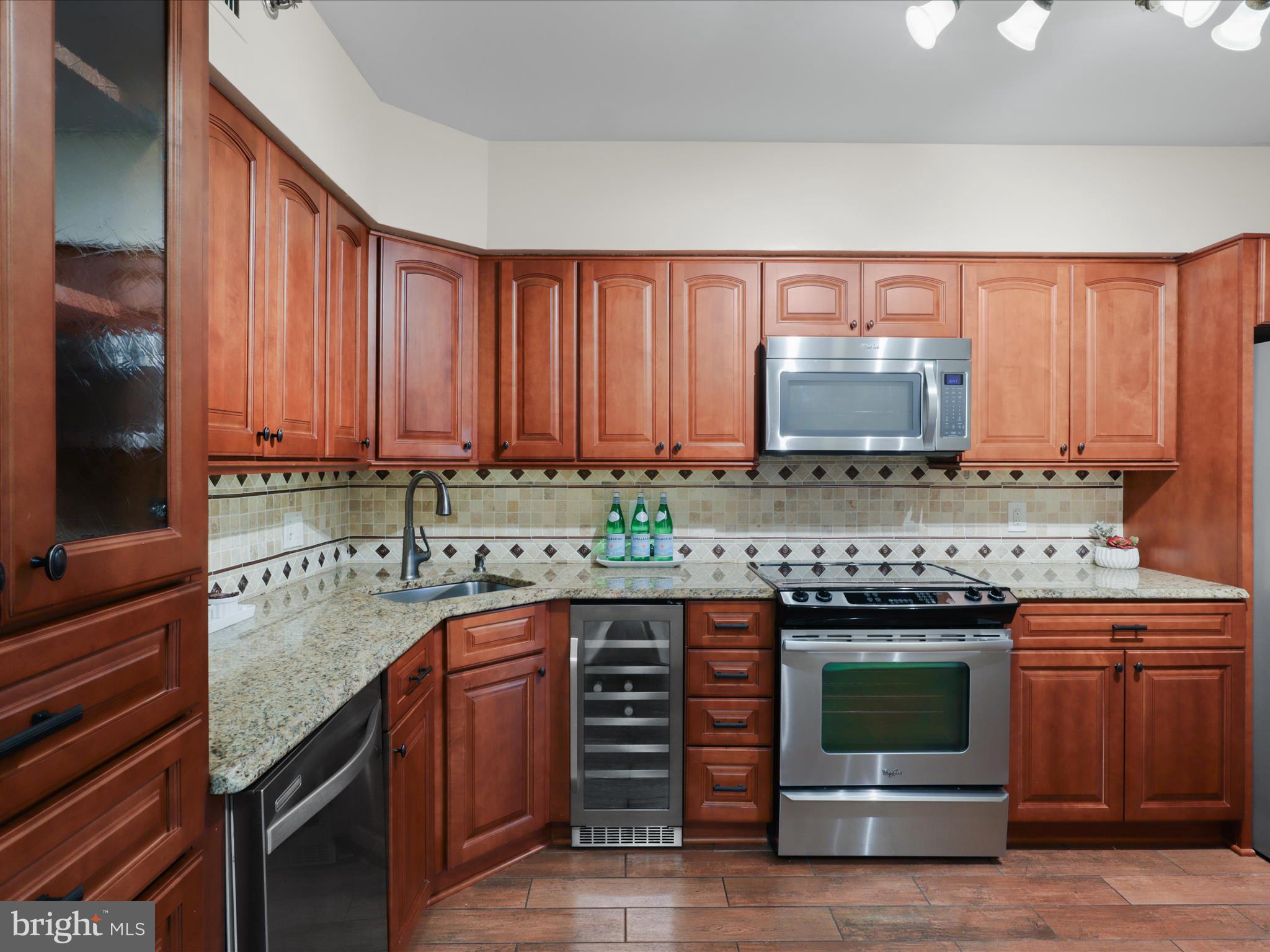 a kitchen with stainless steel appliances wooden cabinets and a stove top oven