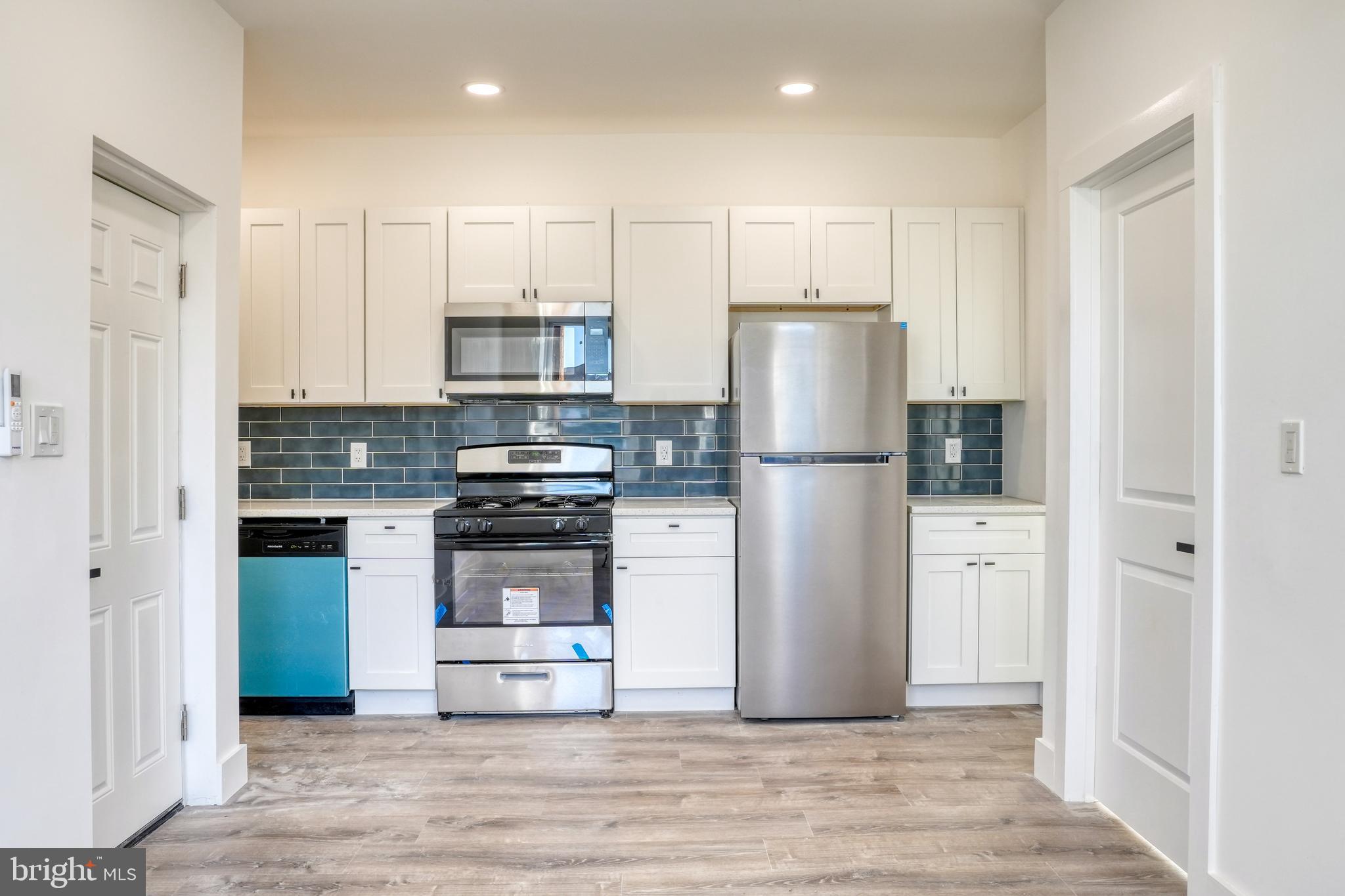 a kitchen with a refrigerator cabinets and wooden floor