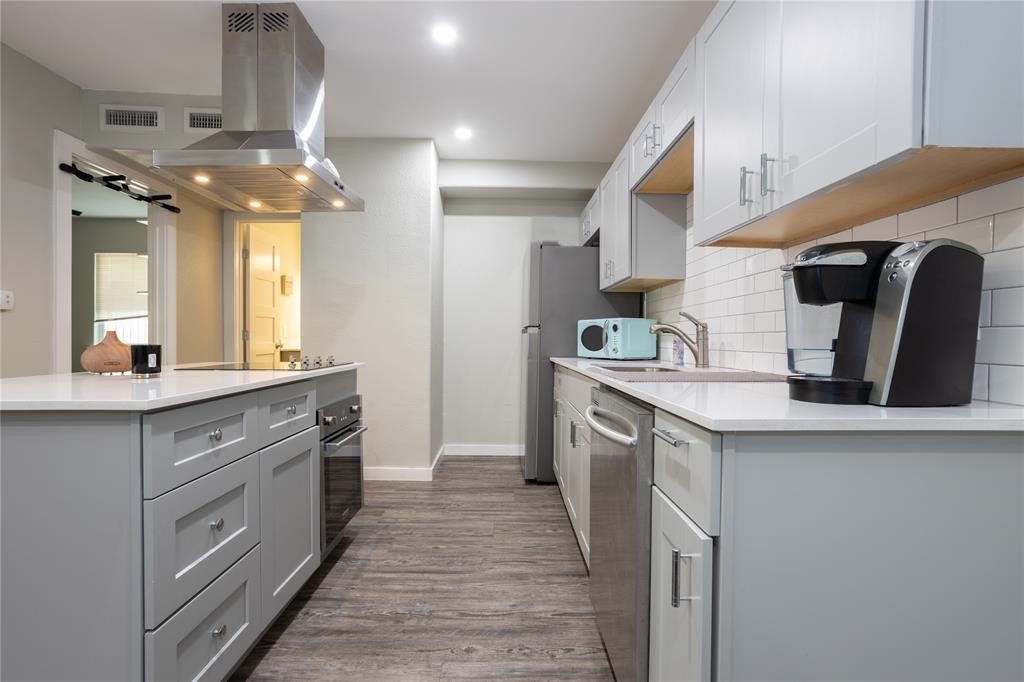 a kitchen with kitchen island granite countertop a sink and refrigerator