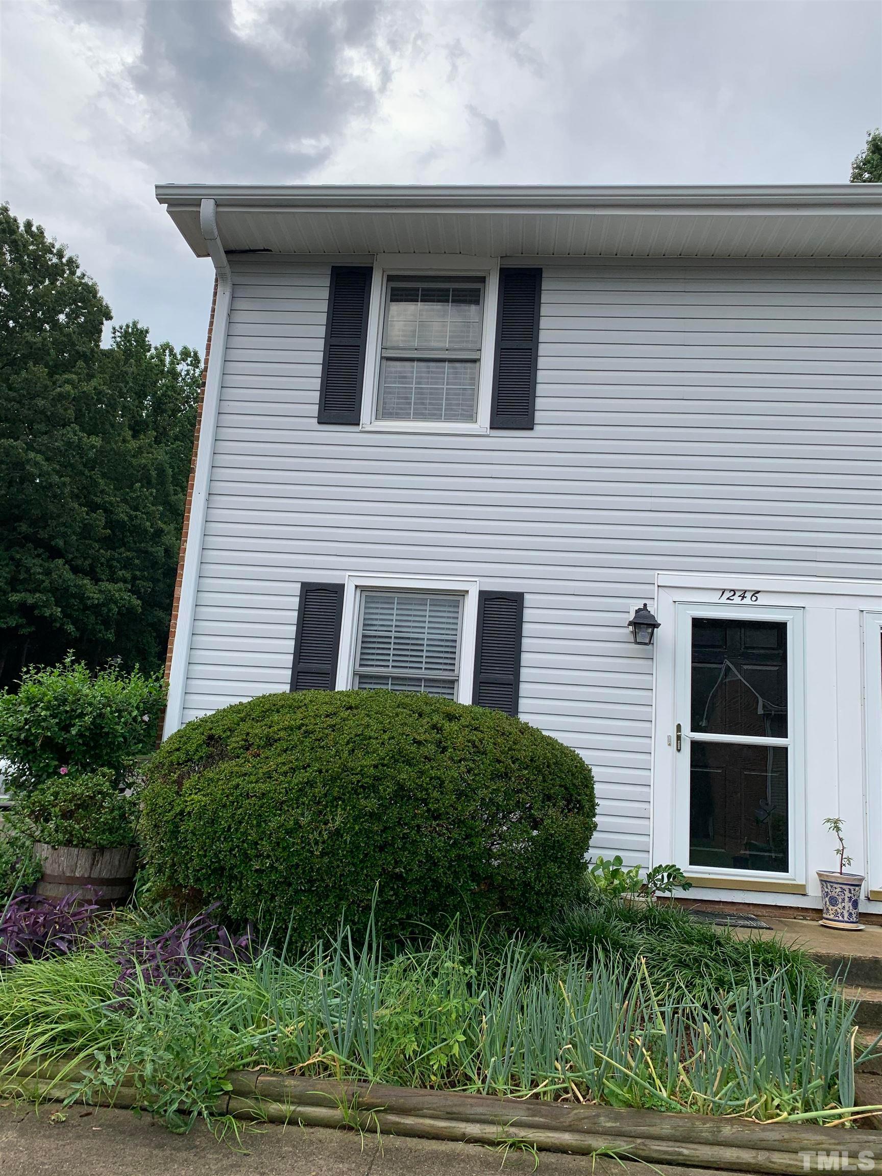 a brick house with a yard potted plants