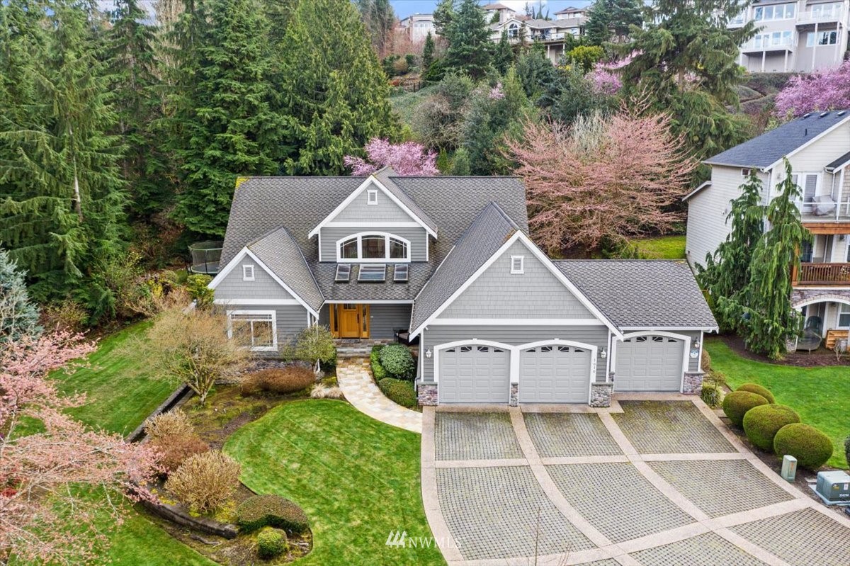 a white house with a small yard and large trees