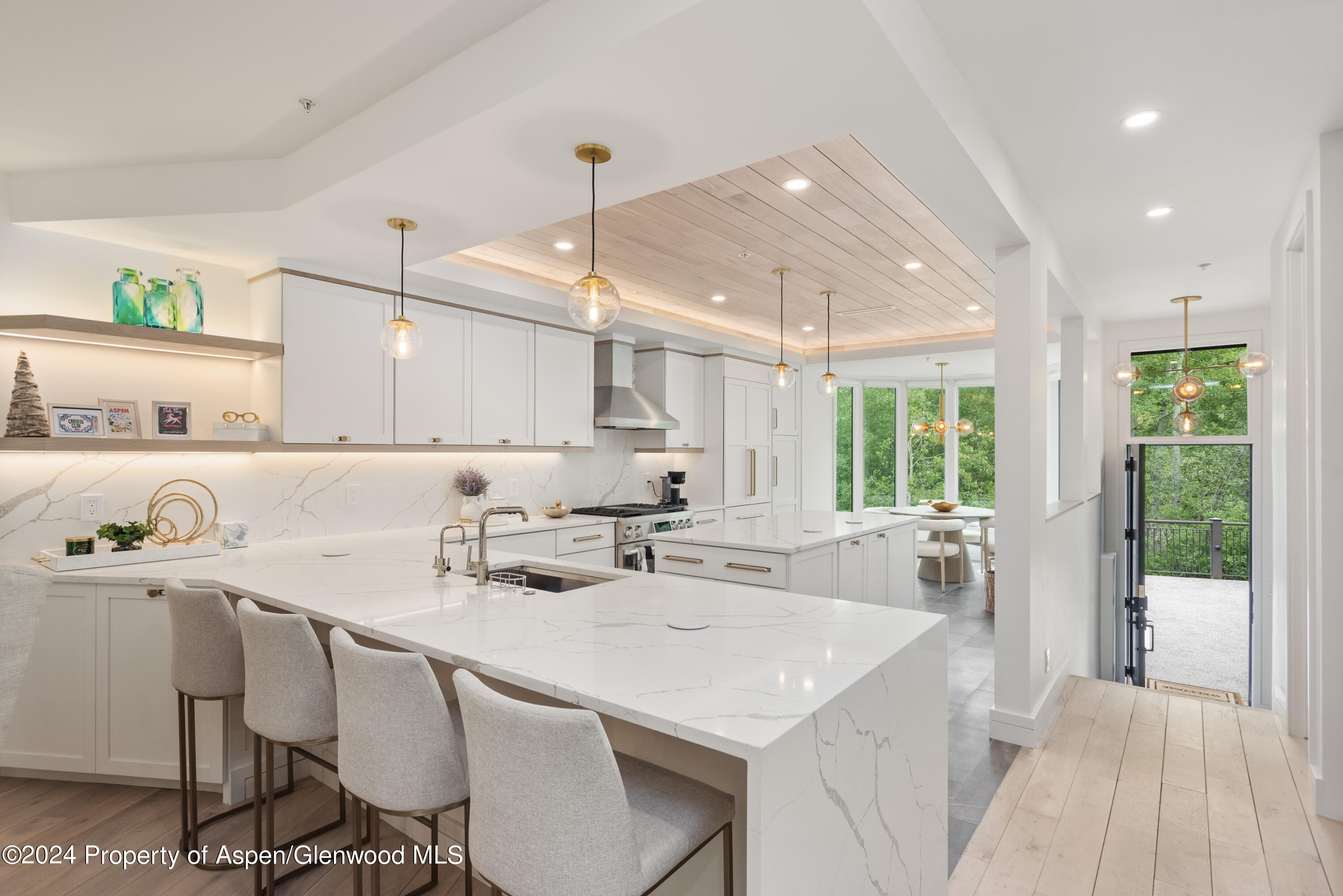 a kitchen with a sink a stove a refrigerator and chairs