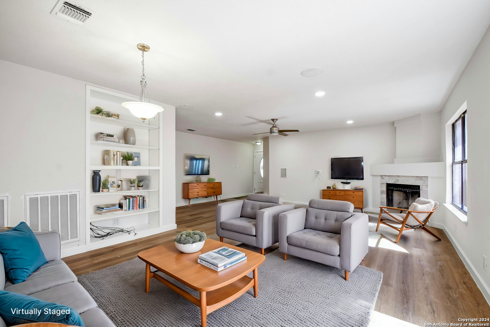 a living room with furniture a fireplace and a flat screen tv