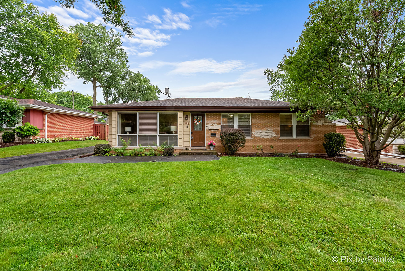 a front view of house with yard and green space