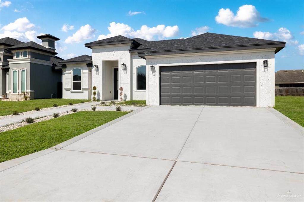 a front view of a house with a yard and garage