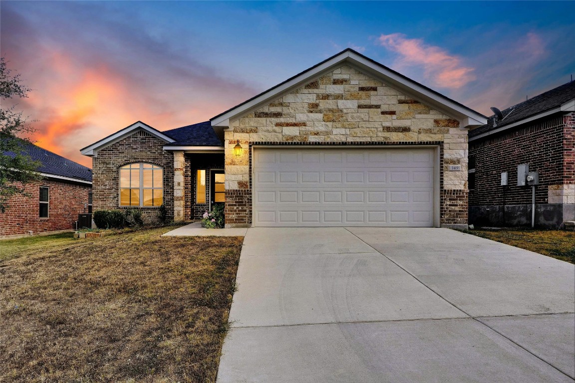 a front view of a house with a yard and garage