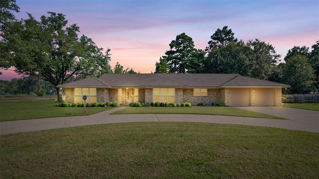 a front view of a house with a yard and trees