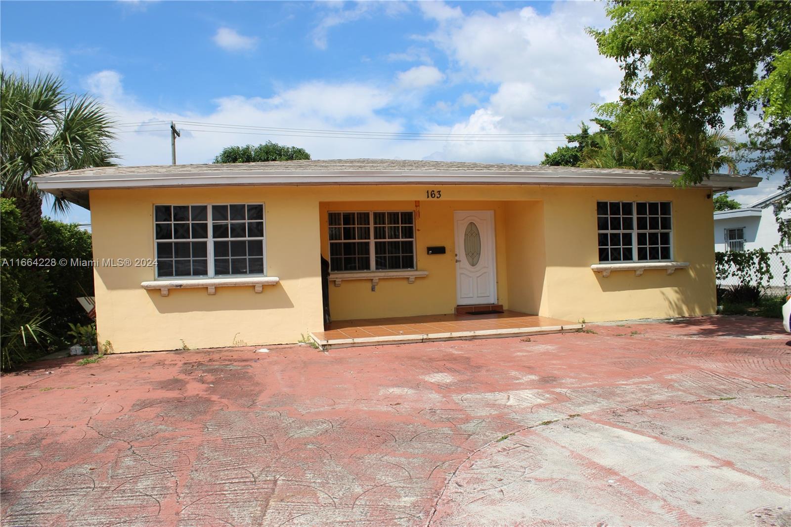 a view of a house with backyard and a tree