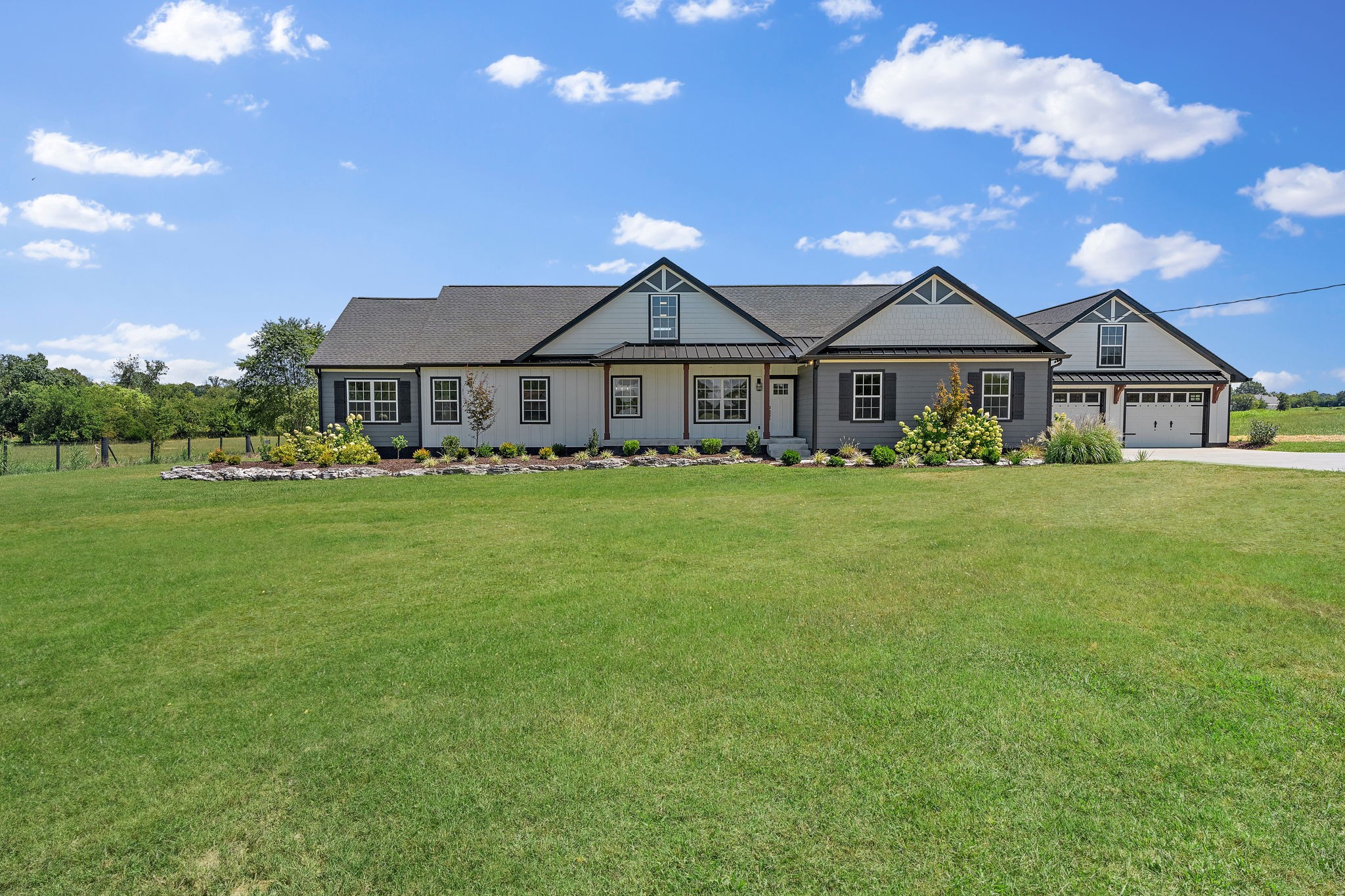 a view of a house with a big yard and large trees