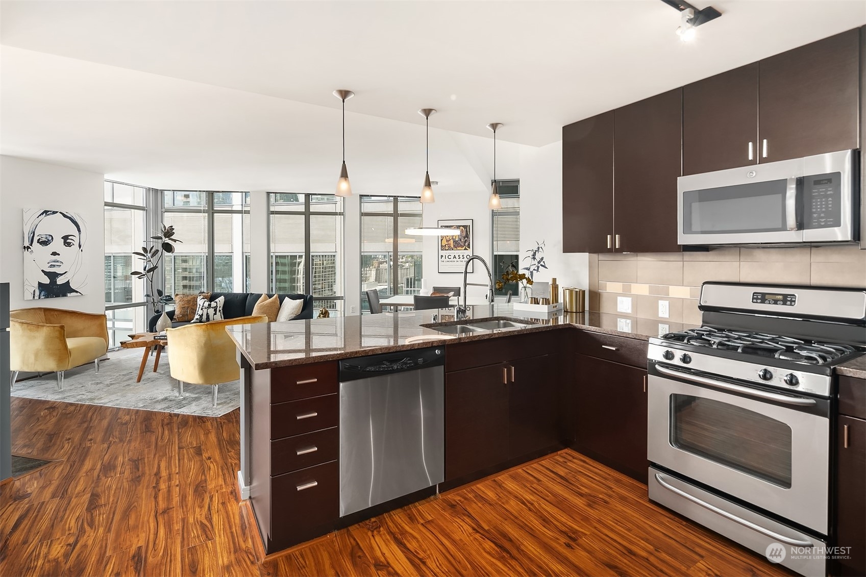 a kitchen with stainless steel appliances granite countertop a stove a sink and a microwave