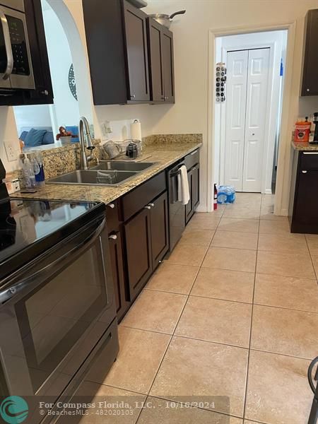 a kitchen with a sink and a stove top oven