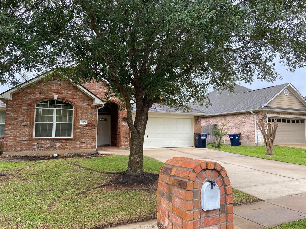 Ranch-style house with a garage and a front lawn