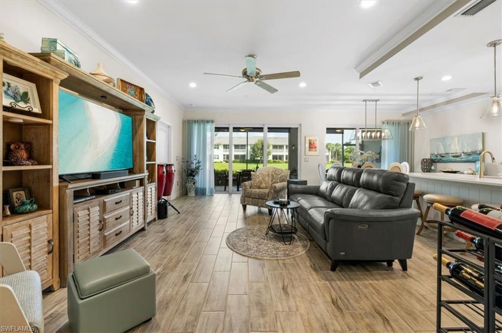 Living room featuring light hardwood / wood-style floors, crown molding, sink, and ceiling fan