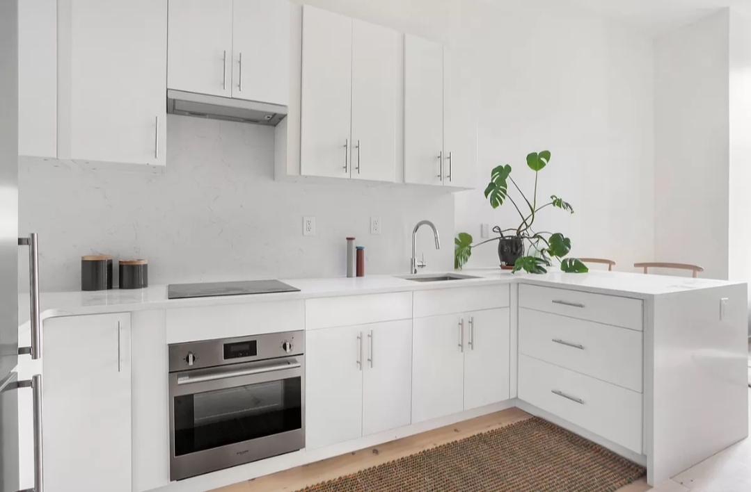 a kitchen with white cabinets and white appliances