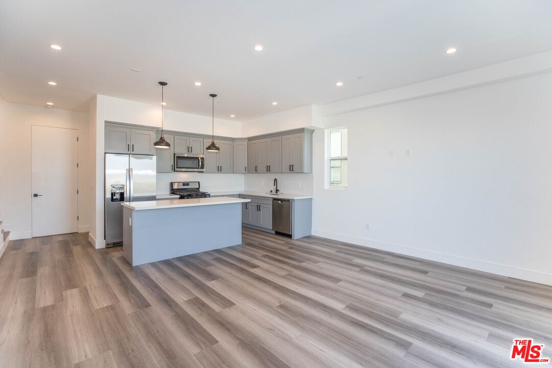 a large kitchen with kitchen island a sink stainless steel appliances and cabinets