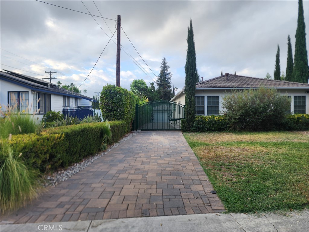 a front view of a house with a yard and potted plants