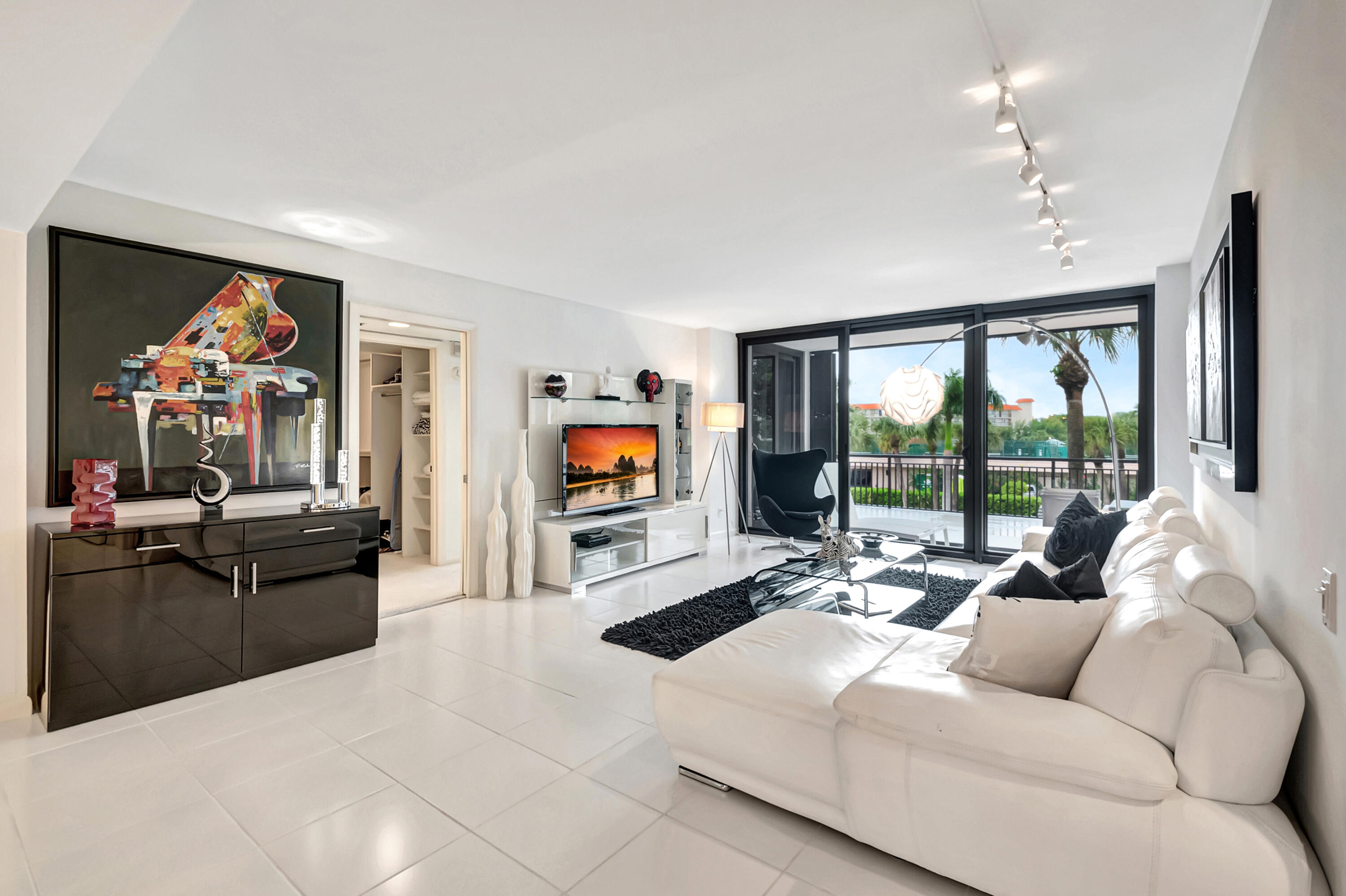 a living room with furniture a flat screen tv and a large window