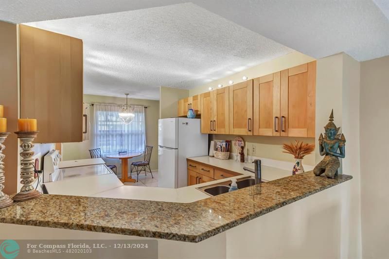 a kitchen with stainless steel appliances granite countertop a sink and a refrigerator