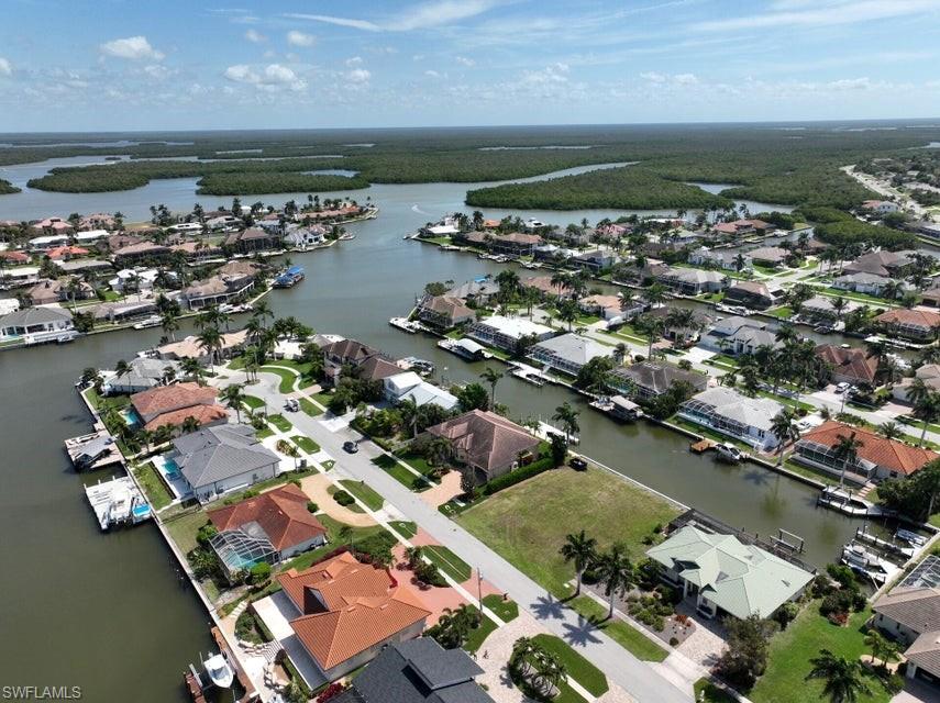 an aerial view of ocean and residential houses with outdoor space