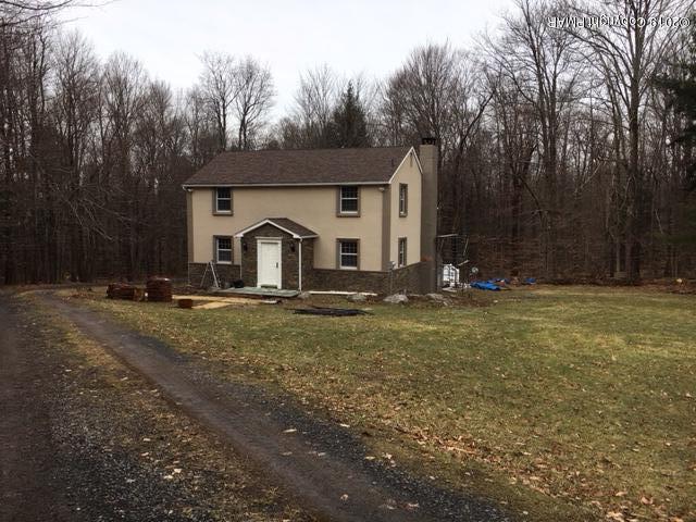 a front view of house with yard and trees