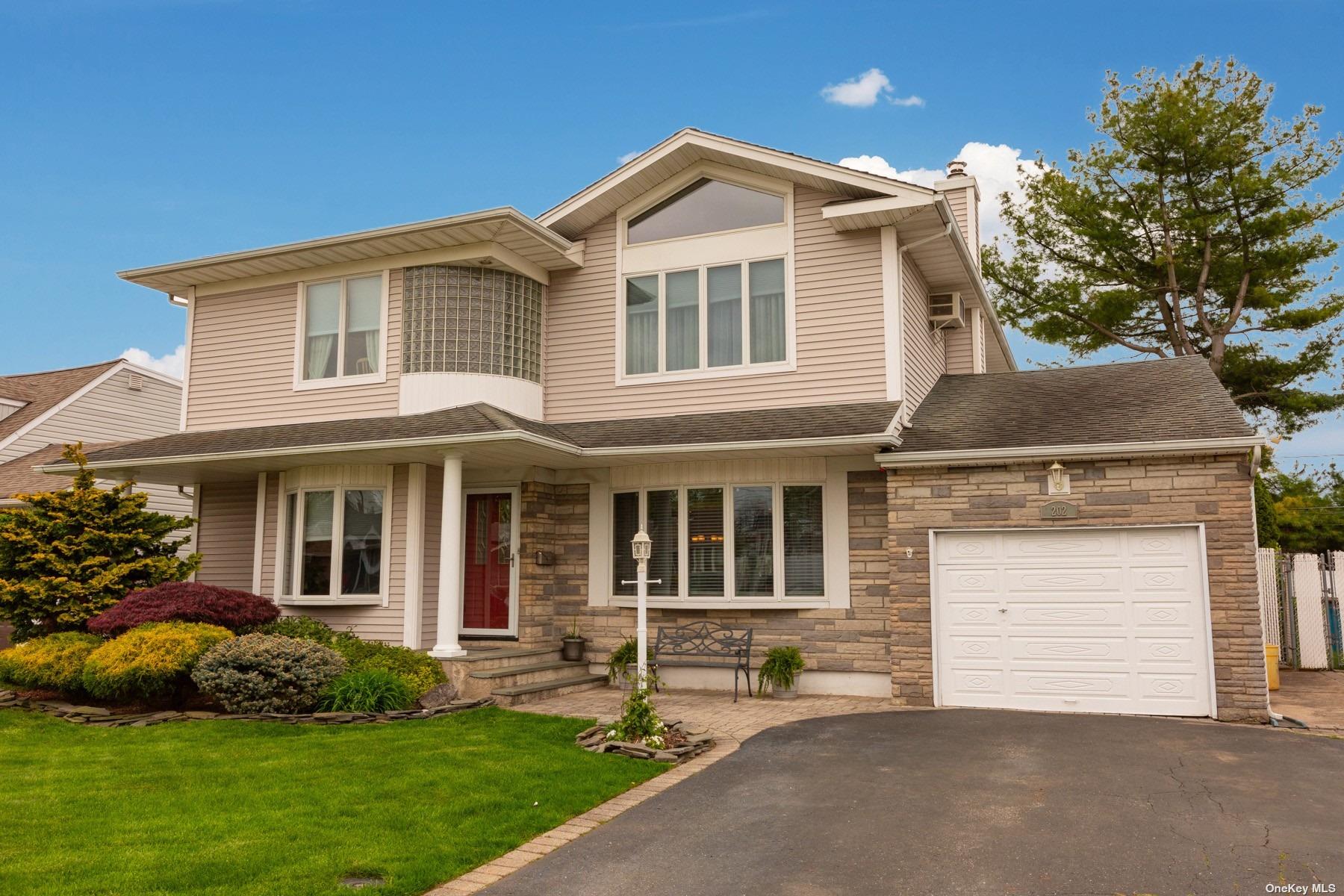 a front view of a house with a garden and yard