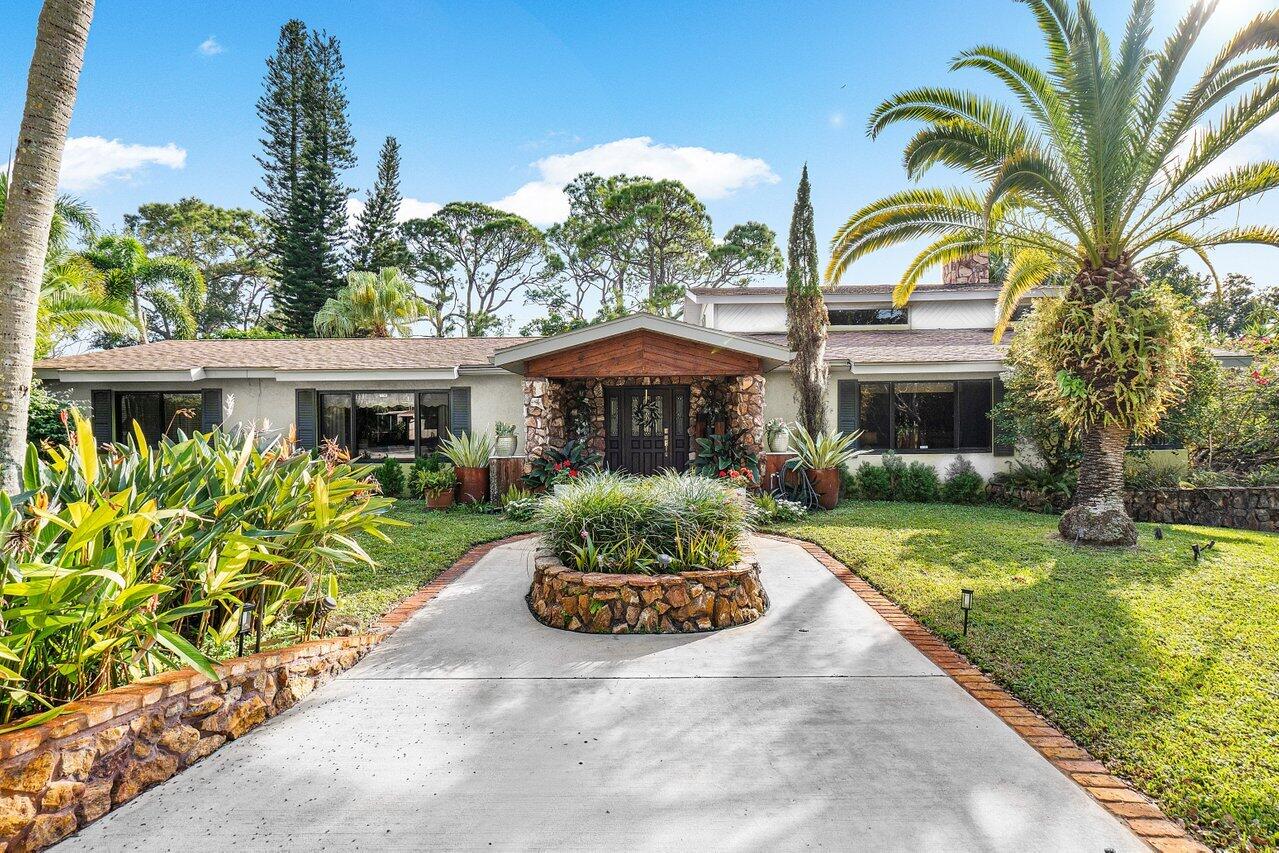 a front view of a house with a garden and a yard