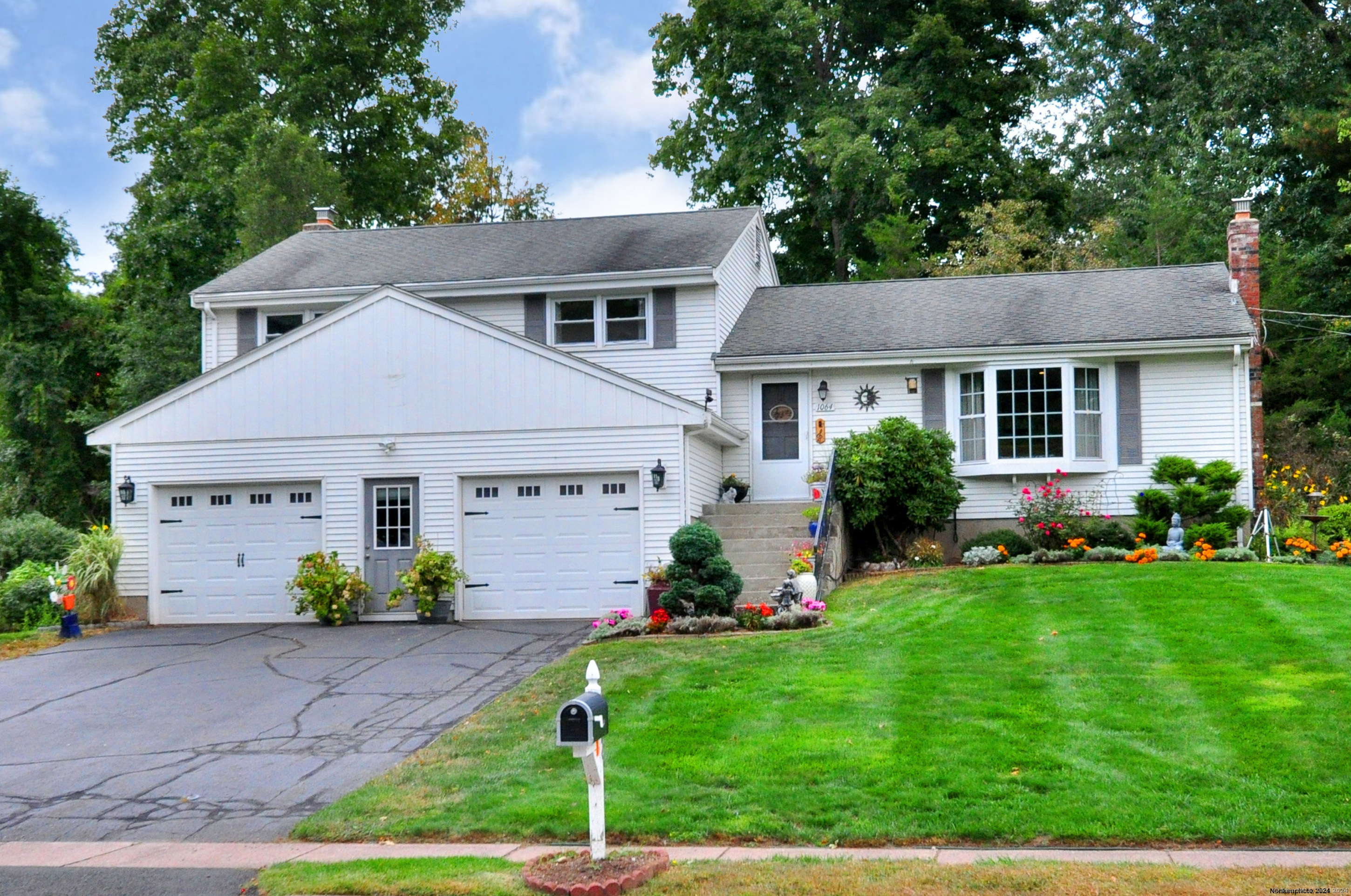 a front view of a house with a garden