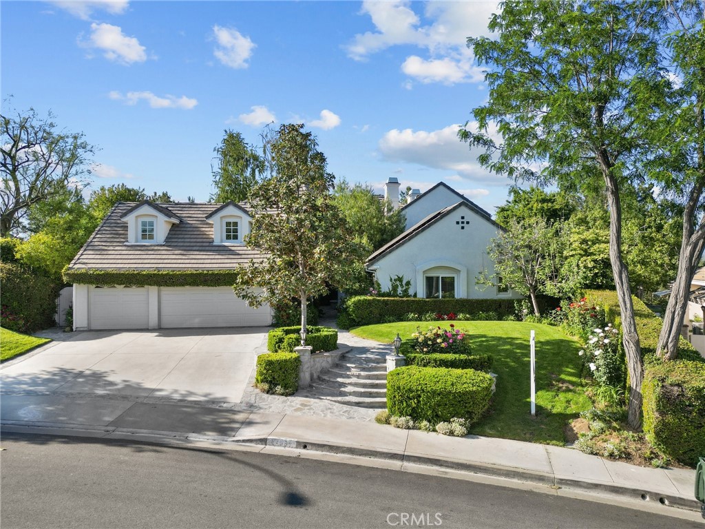 a front view of a house with a yard and trees