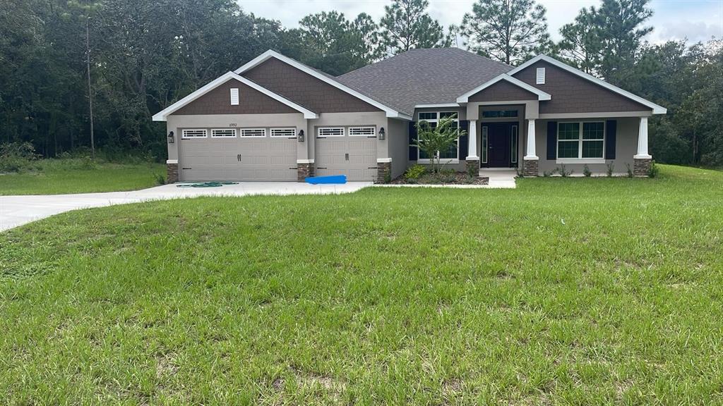 a front view of a house with a yard and large trees